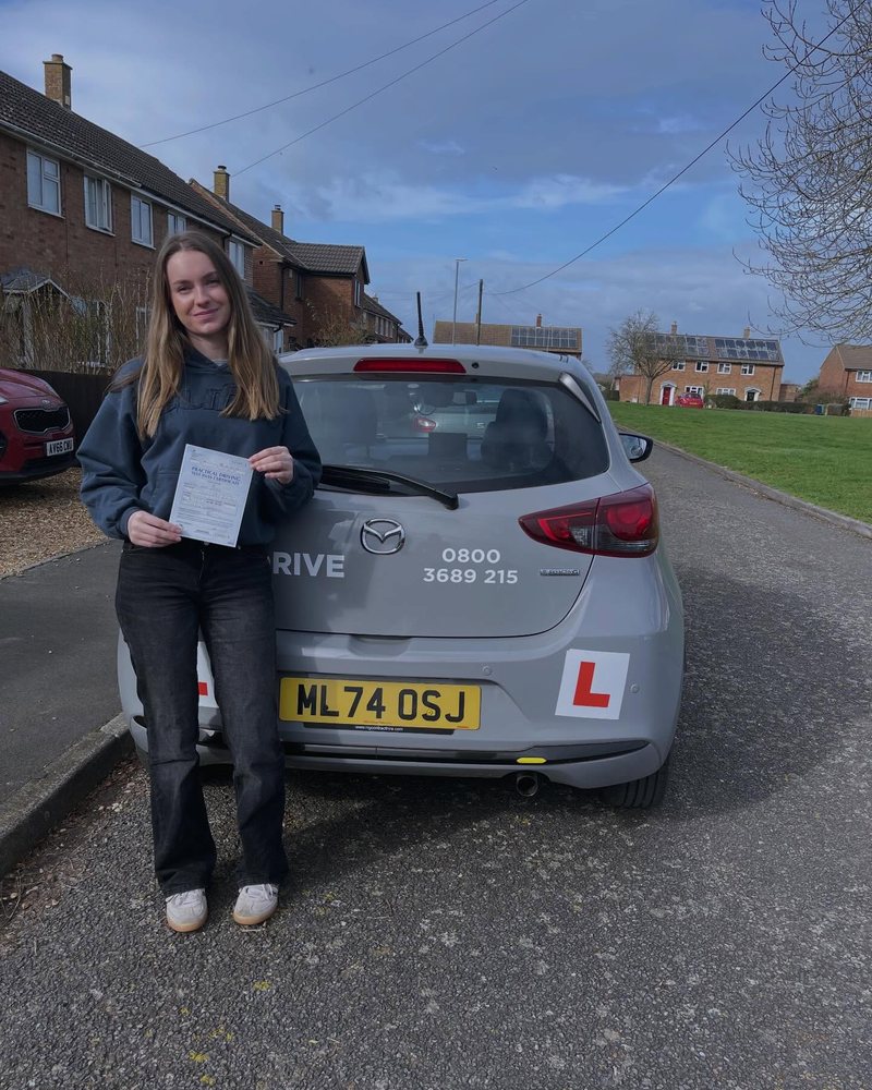Happy learner holding a driving test pass certificate