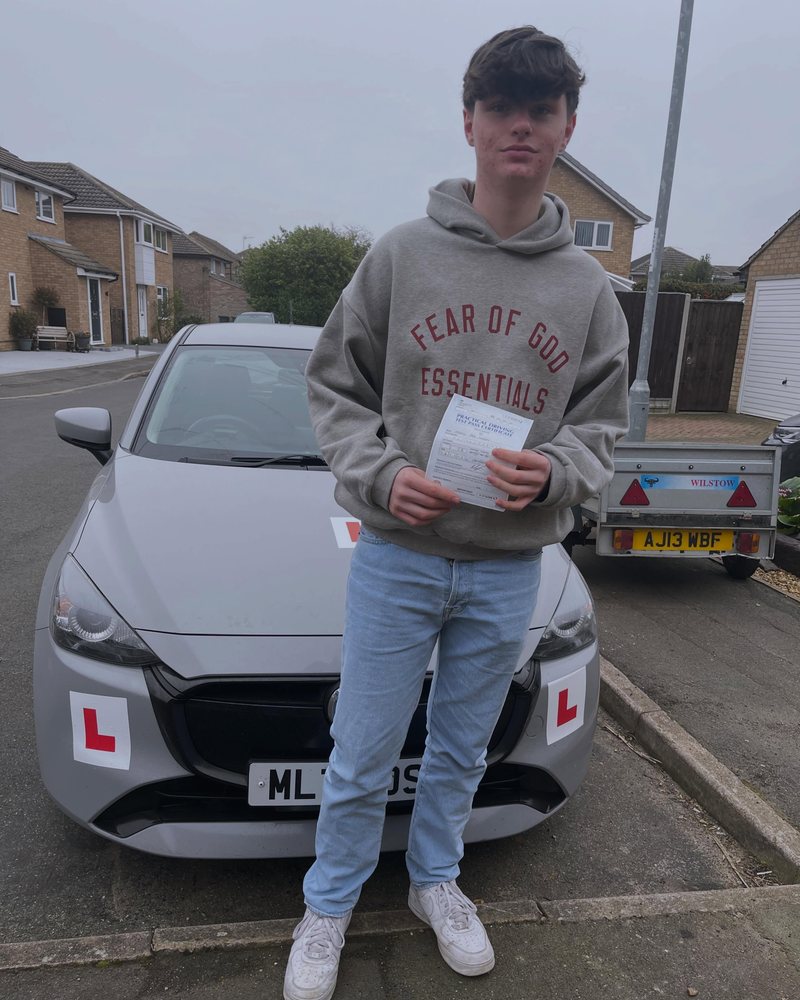 Young driver with a driving test pass certificate in Cambridgeshire